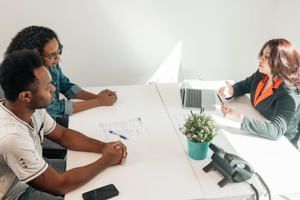 Two adults consulting a legal advisor in a modern office