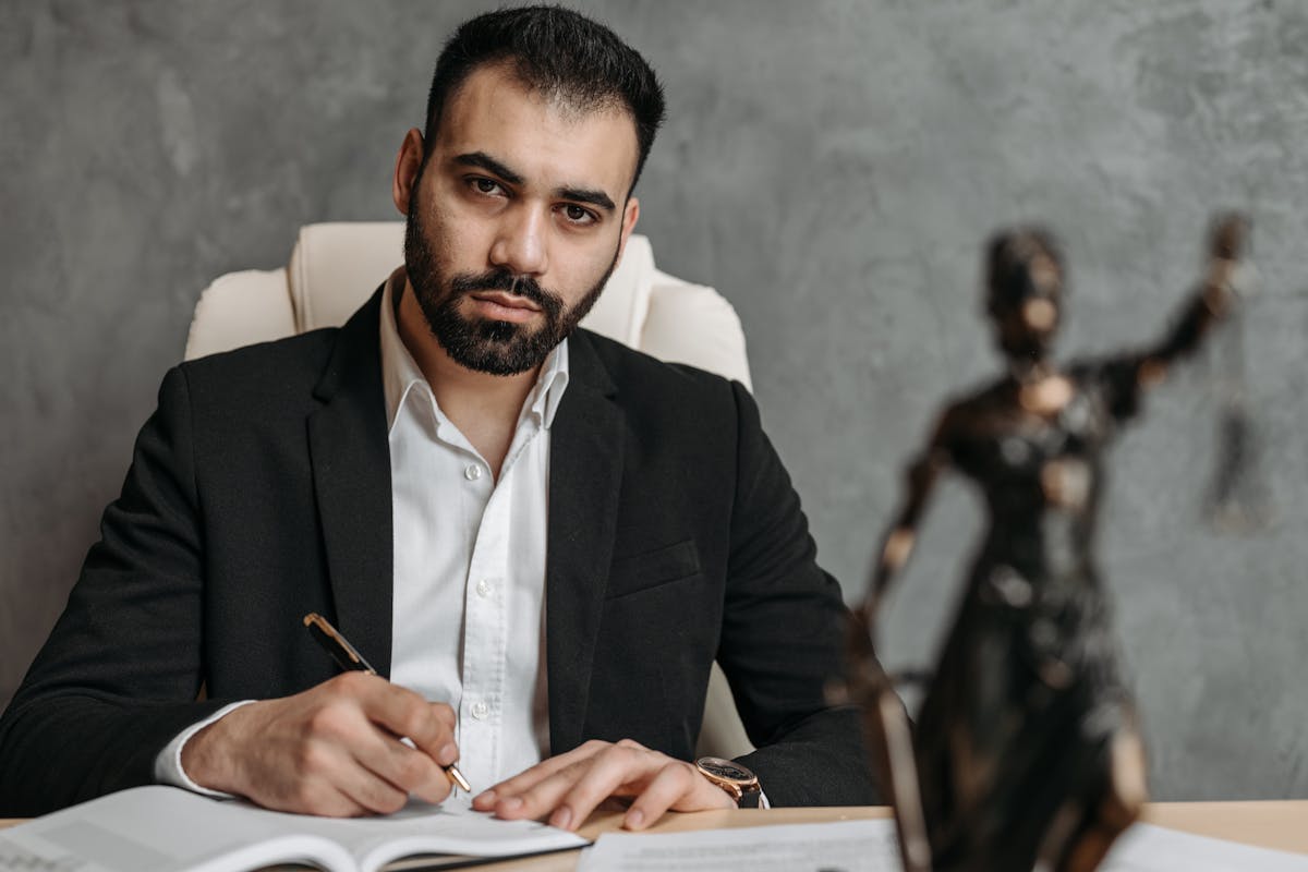 A Man in Black Suit Holding a Pen